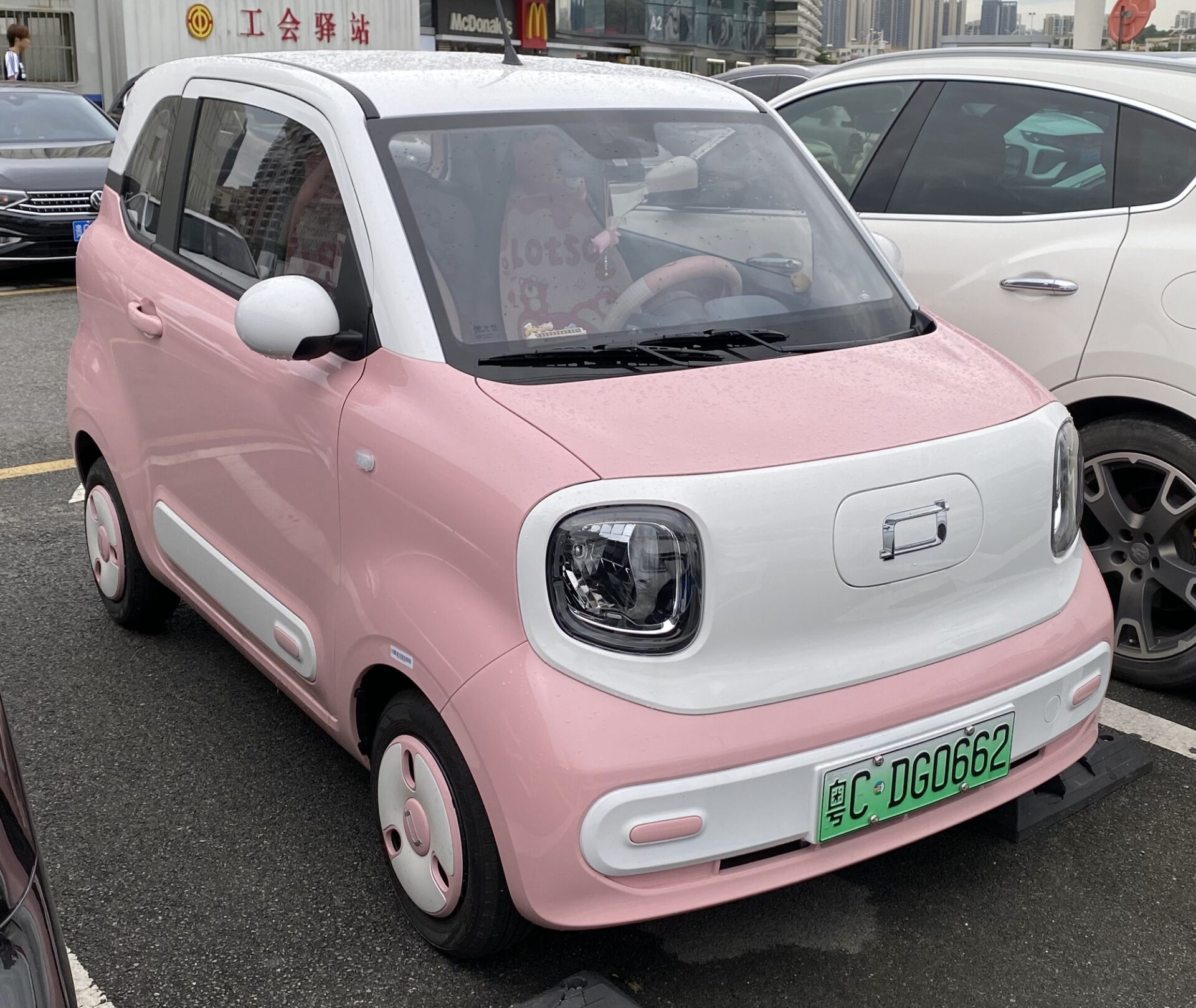 Розовый электромобиль BESTUNE XIAOMA (Pony), снятый спереди на парковке в Китае